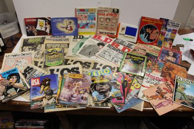 une table sur laquelle sont posés de nombreux magazines et livres