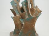a bronze sculpture of a piece of art on a white surface