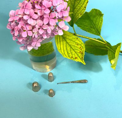 a vase of flowers and a pair of earrings on a table