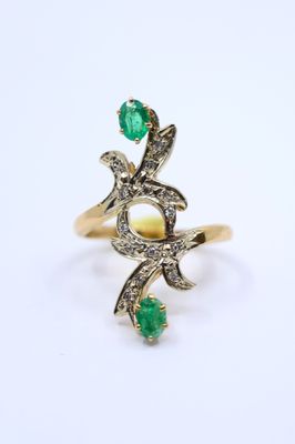 a gold ring with a green stone and diamonds