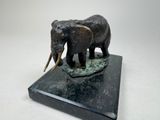 a statue of two elephants that are standing on a marble base