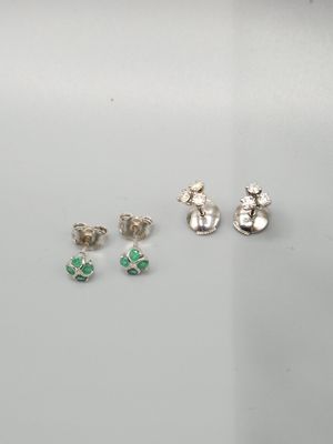 trois paires de boucles d'oreilles argentées et vertes posées sur un fond blanc