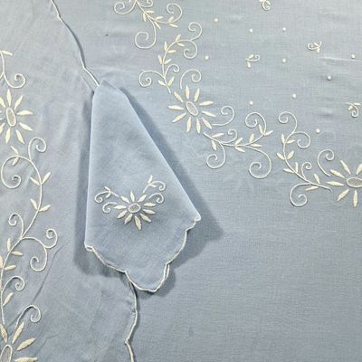 a blue table cloth with white embroidery on it
