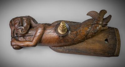 wooden sculpture of a woman laying on a wooden plank with a candle in her hand