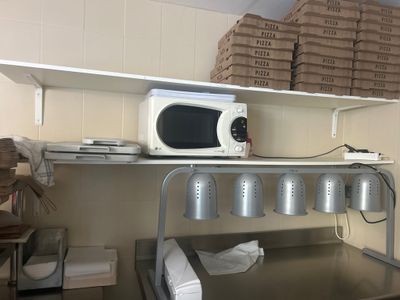 a microwave sitting on top of a shelf in a kitchen