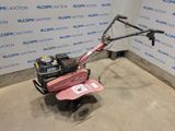 an image of a pink lawn mower parked in a garage