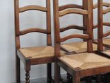 four wooden chairs sitting next to each other in a room