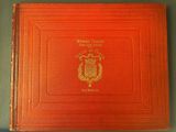 an orange book with a gold emblem on it sitting on top of a table