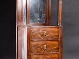 an antique wooden display cabinet with glass doors and drawers