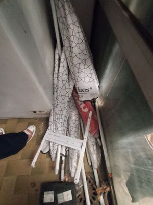 une personne se tient à côté d'un tas de parapluies posés par terre