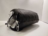 un sac noir posé sur une table, sur fond blanc