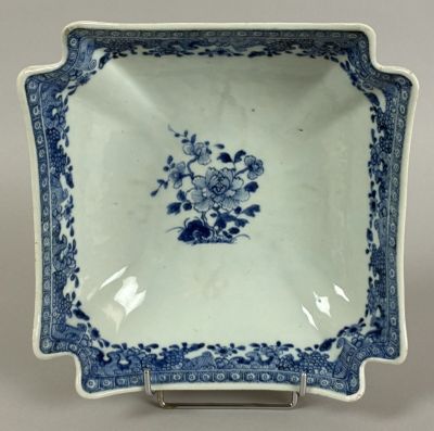 blue and white plate with flowers on it on a metal stand