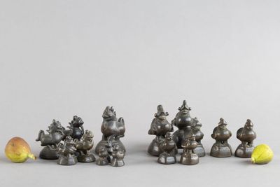 quatre petites figurines métalliques représentant des animaux et une poire posées sur une table