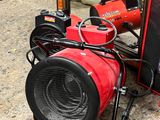 a red blower sitting on the ground next to a fire hydrant