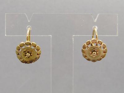 deux paires de boucles d'oreilles en or exposées dans une vitrine transparente