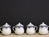four blue and white teapots lined up on a table