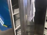 a large stainless steel refrigerator in a kitchen with a blue towel hanging from the door