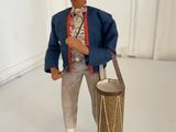 figurine of a man with a drum and a hat