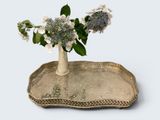 un vase avec des fleurs sur un plateau sur une table
