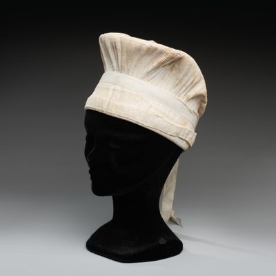 une image représentant une tête de mannequin noire coiffée d'une toque de chef