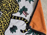 the towel has a cheetah design on it and is on the floor