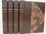 four brown books are lined up in a row on a white surface