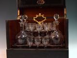 bottles and glasses in a wooden case on a table