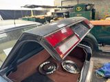 an old car with its trunk open in a garage