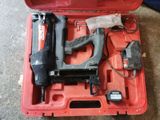 une mallette rouge contenant une agrafeuse et un pistolet à clous