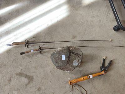 une canne à pêche et un filet de pêche posés par terre