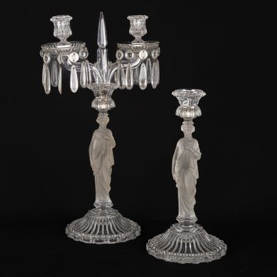 une paire de bougeoirs en cristal taillé, ornés chacun d'une figurine