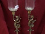 paire de bougeoirs anciens en laiton, avec des poignées en forme d'ange et un abat-jour en verre transparent