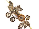 une image représentant une broche ornée de fleurs et de feuilles sur fond blanc
