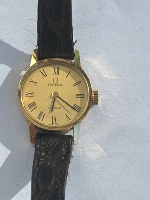 a gold watch with roman numerals on a black strap