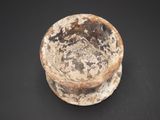 a dirty bowl sitting on a table with a black background