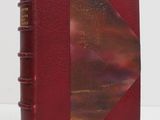 a red book sitting on top of a table next to a white wall