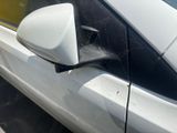 a white car with a spider web on the side of it