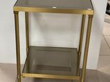 a glass and brass side table with a glass shelf