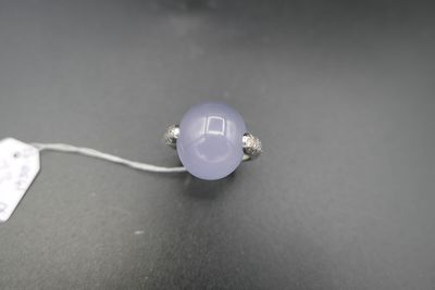 une image représentant une bague ornée d'une pierre violette sur un fond noir