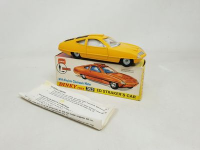 an orange toy car sitting on top of a white table