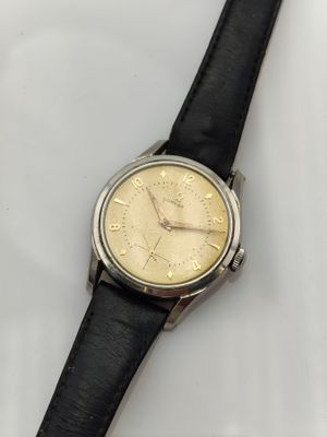 a close up of a watch on a white surface with a black strap
