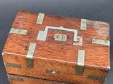 a small wooden box with metal handles on a table