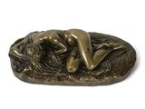 statue en bronze représentant une femme allongée sur un rocher avec un lion