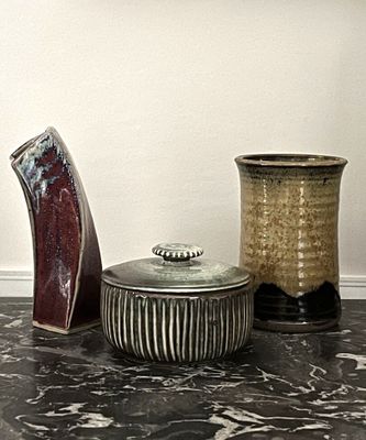 trois vases différents posés sur un plan de travail en marbre