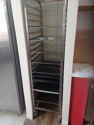 un réfrigérateur ouvert dans une cuisine où se trouve une poubelle rouge