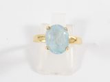 a close up of a gold ring with a blue topaz stone