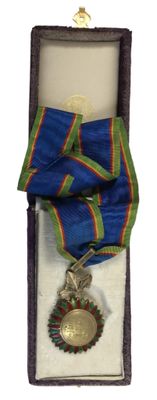 une médaille dans un écrin, entourée d'un ruban