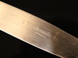 a close up of a knife on a black surface