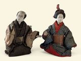 paire de figurines asiatiques représentant un homme et une femme accompagnés d'un chien