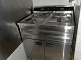 une cuisine équipée d'une cuisinière, d'un évier et d'un réfrigérateur